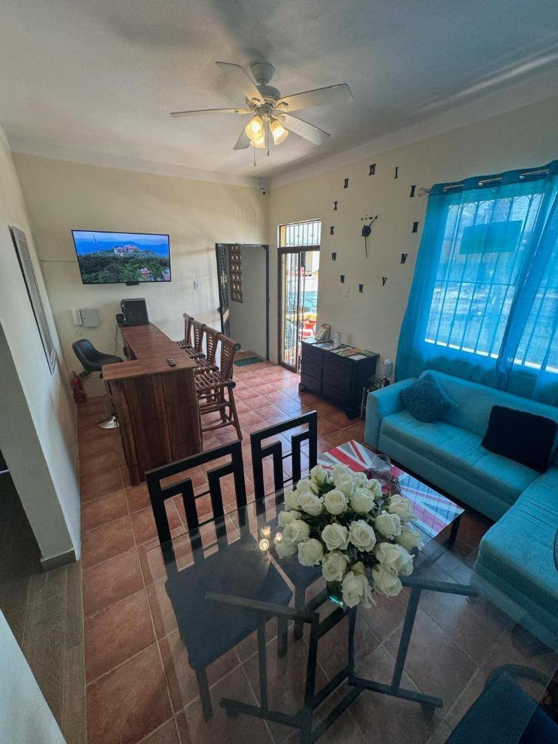 Living and dining area with a blue sofa and a TV