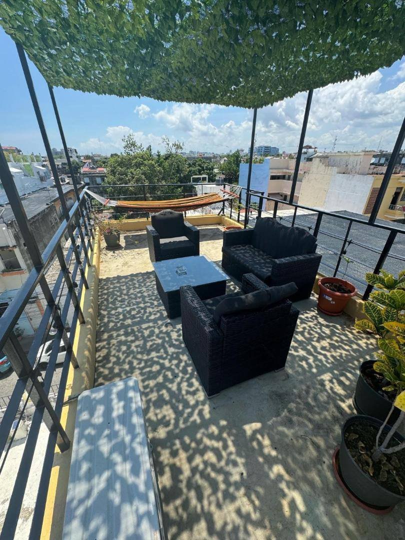 Rooftop lounge area with armchairs and a hammock