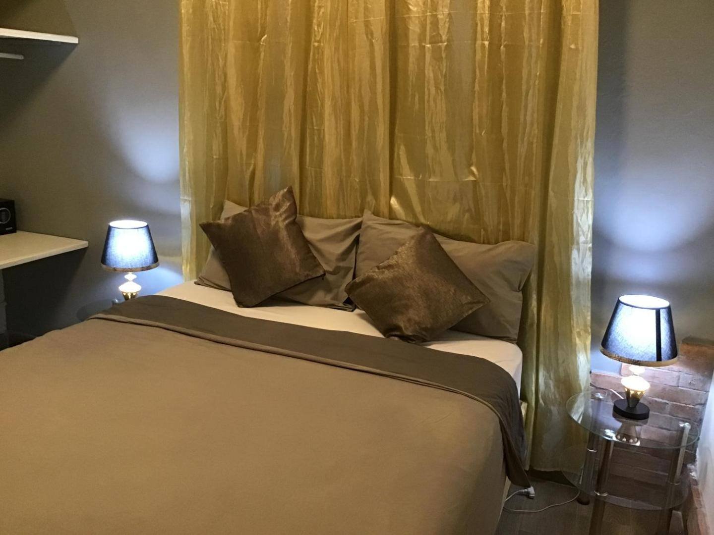 Double room with a bedside lamp and golden curtains